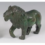 Anthony Chauke - a polished green serpentine model of a standing lion, its front right paw raised,