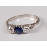 An early 20th century white metal, sapphire and diamond three-stone ring, featuring a centre round