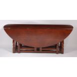 A C17th style joined oak double gateleg wake table, of good size, the oval fall leaves, raised on