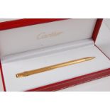 A Must de Cartier gilt metal stylo pen, the body with reeded decoration, presented within original