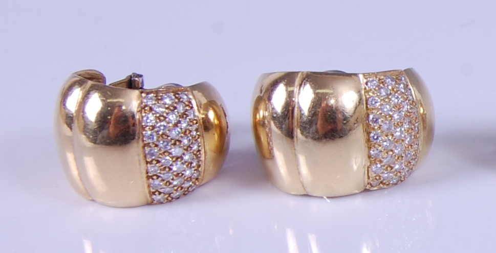 A pair of yellow metal diamond set half hoop style ear clips, each with a pavé set section of 33