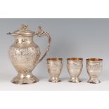 An Indian silver and silver gilt wine ewer with three matching beakers, the ewer having hinged cover