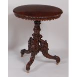 A 19th century Burmese rosewood topped circular fixed pedestal tripod table, with chip carved and