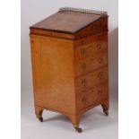 An early 19th century amboyna campaign davenport, with hinged sliding and brass galleried top,
