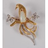 A contemporary yellow metal, opal and diamond set bird brooch, the bird perched upon a branch,