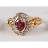 A yellow metal, ruby and diamond oval cluster ring, comprising a centre oval faceted ruby within a