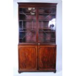 A late Georgian mahogany bookcase cabinet, the upper section having twin astragal glazed doors