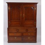 An 18th century joined and panelled oak housekeepers cupboard, the upper section having twin fielded