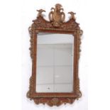 A walnut and gilt composition framed wall mirror, in the George II style, the whole surmounted