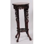 A Circa 1900 Chinese 'rosewood' and rouge marble inset urn stand, having all over floral carved