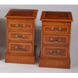 A pair of figured walnut cross and feather banded bedside chests, each having brushing slide over