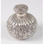 A late Victorian silver scent bottle, of squat circular form, having screw cap, the body embossed