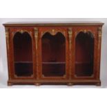 A French kingwood and gilt metal mounted three door glazed side cabinet, the shaped doors surrounded