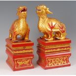 A decorative pair of Chinese gilt and red pained hardstone temple turtle dragons, each raised on