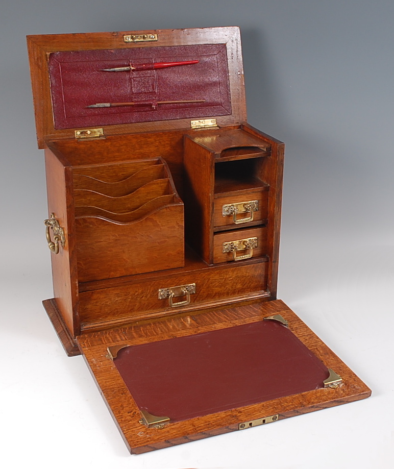 A Victorian oak stationery cabinet, with cut brass mounts, the hinged cover and fall-front opening