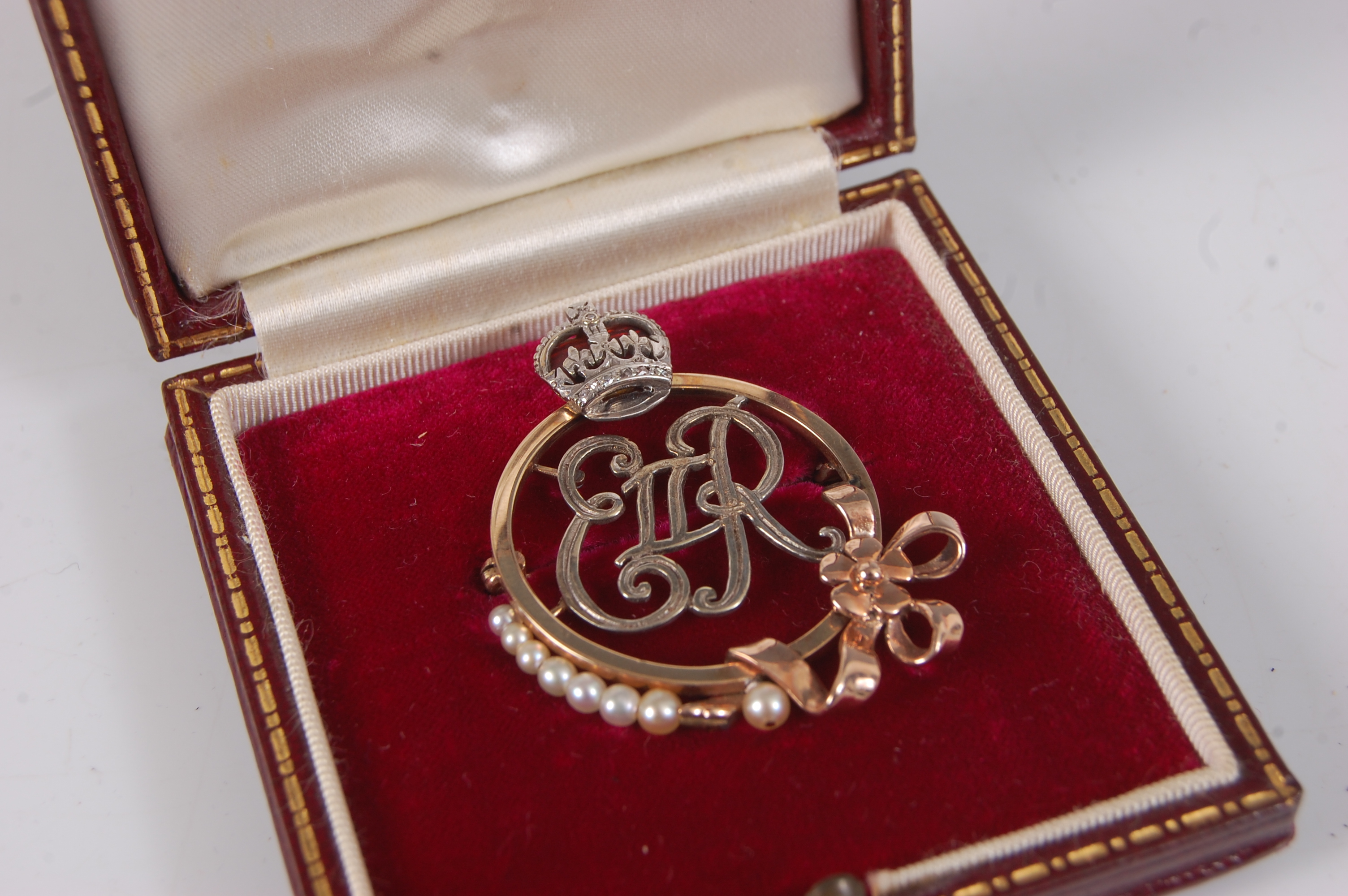 A yellow and white metal Elizabeth II Royal monogram brooch, of circular form with ERII initials