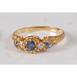 A late Victorian yellow metal, sapphire and diamond five stone half hoop ring, the three graduated