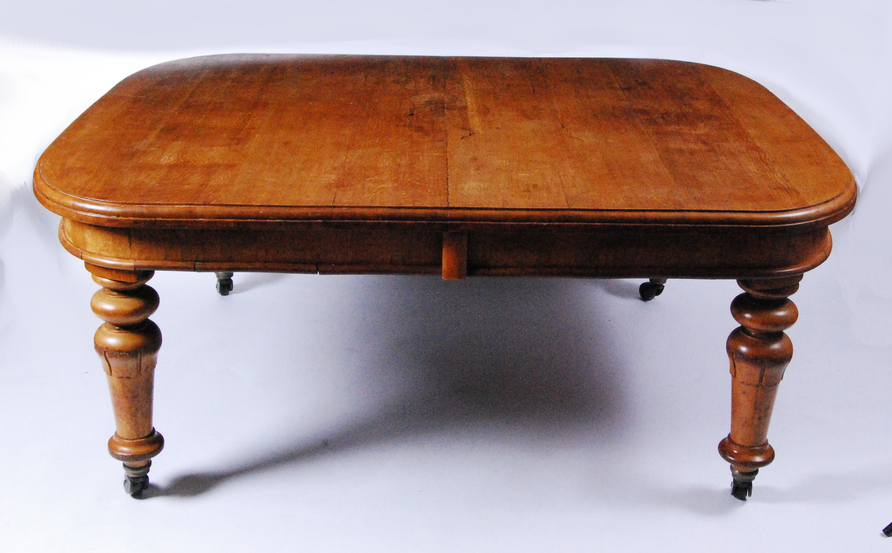 A Victorian oak extending dining table, of good size, the top having a moulded edge, four drop-in