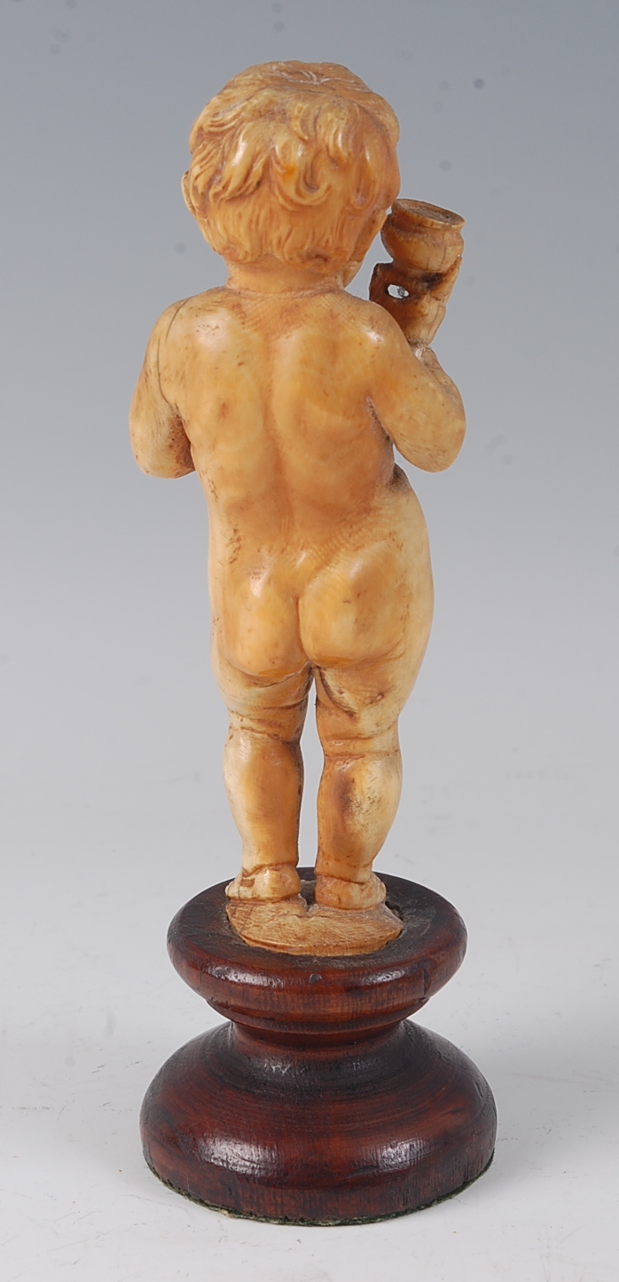 A 19th century continental carved ivory figure of a standing nude boy, holding a bunch of grapes and - Image 3 of 3