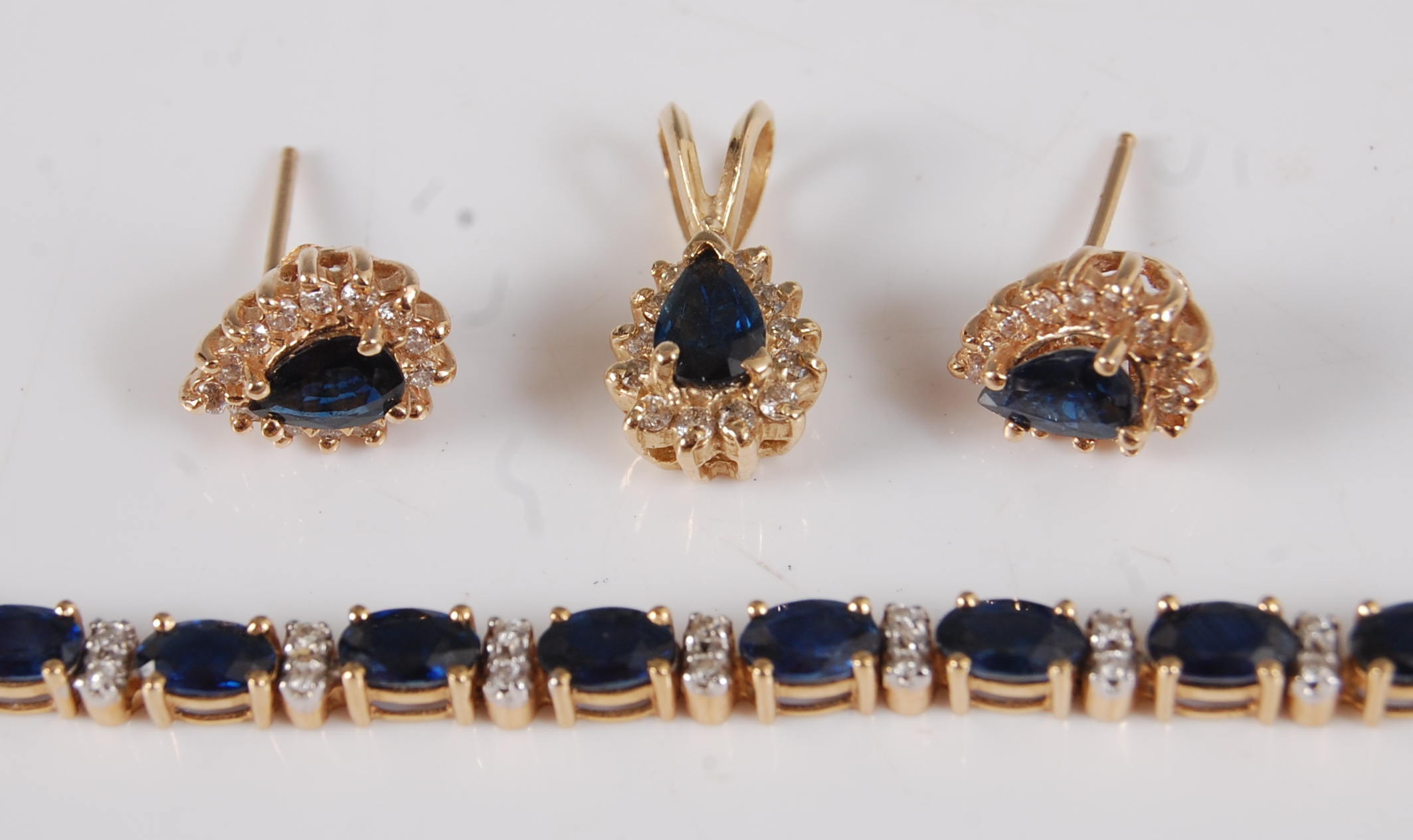 A contemporary 18ct gold, sapphire and diamond point set bracelet, arranged as 25 four-claw set oval