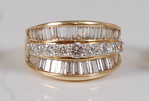 A contemporary 14ct gold diamond dress ring, arranged as a centre row of nine four-claw set