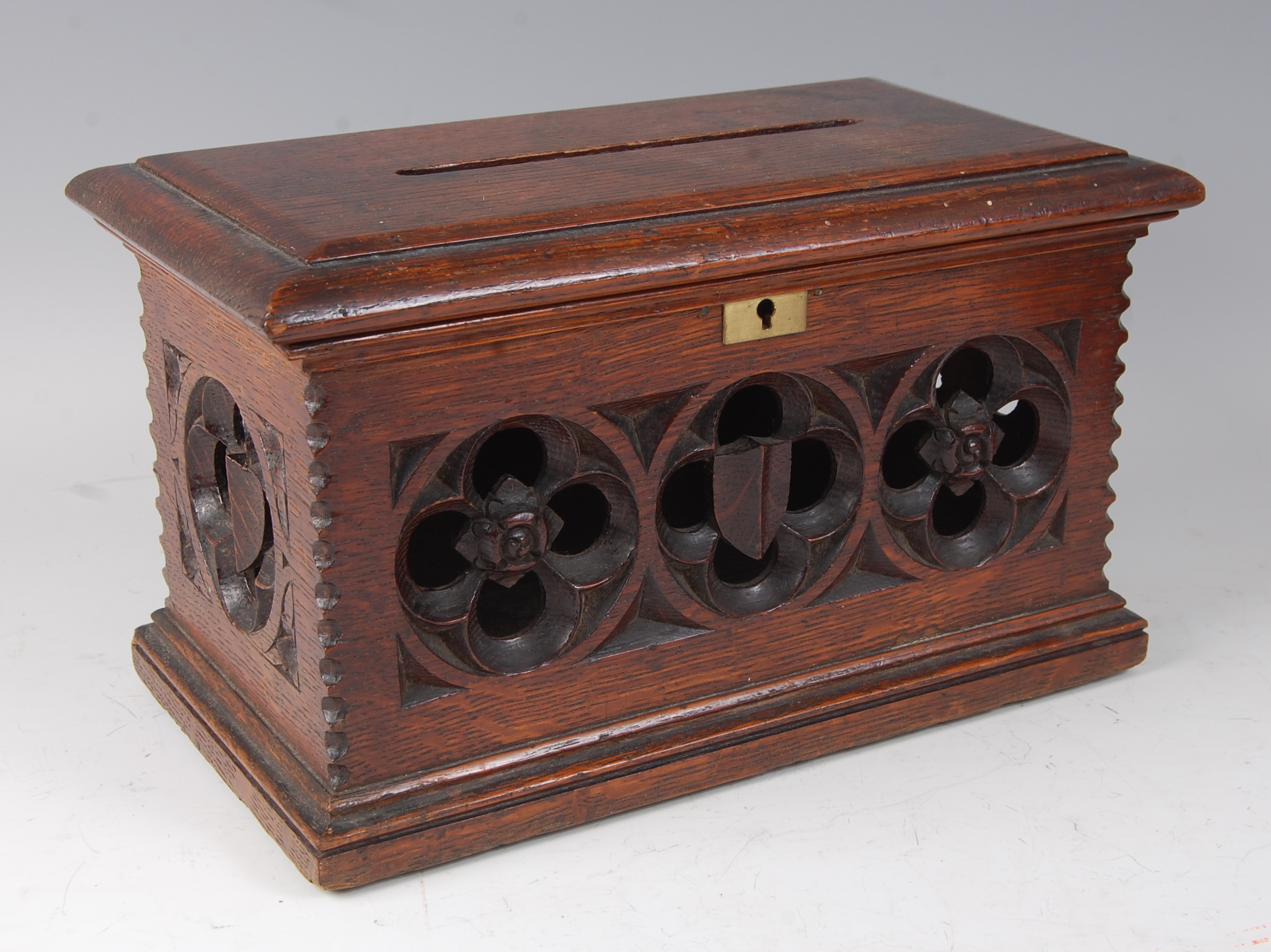 A Victorian carved oak offertory box, having hinged cover and Gothic influence flower head carvings,