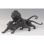 A Japanese Meiji period (1868-1912) bronze group of a lion fighting a tiger, each in roaring pose,