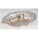 An Edwardian silver bonbon dish, having C-scroll capped pierced rim, the reverse with later