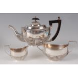 A George V bachelors silver three-piece tea set, comprising teapot, twin handled sugar and cream,