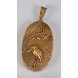 A Japanese Meiji period yellow metal oval picture locket, the obverse decorated with a crane and a