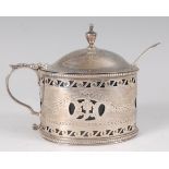 A George III silver mustard pot, having a finial topped hinged dome cover, blue glass liner, pierced