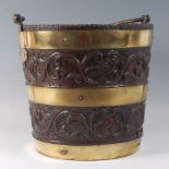 A 19th century coopered oak and brass bound peat bucket, relief carved with two bands of birds