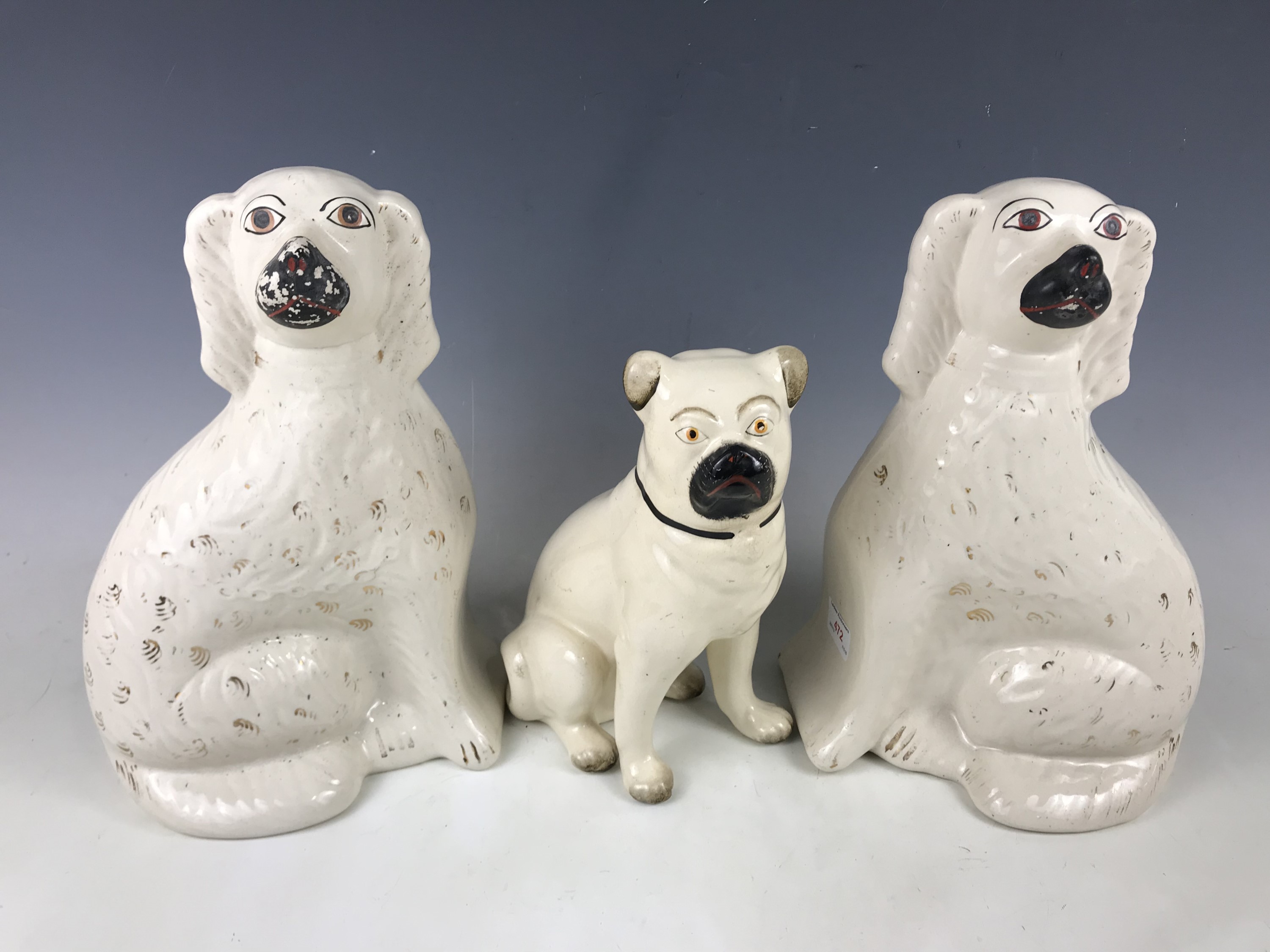 A pair of Staffordshire dogs together with a pug dog