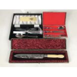 A cased electroplate christening set together with a cased bread knife etc