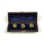 A Victorian cased set of three rolled-gold and emerald green paste set shirt studs, each in the form