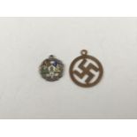 A yellow metal swastika pendant / charm, stamped 9ct, 0.4g, together with an enamelled white metal