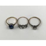 Three vintage yellow-metal dress rings set with paste stones, including a sapphire-blue emerald-