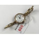A 1920s lady's 9ct gold cased wristlet watch, having a 15 jewel movement, a circular white-enamelled