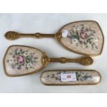 A reticulated brass and petit point dressing table set