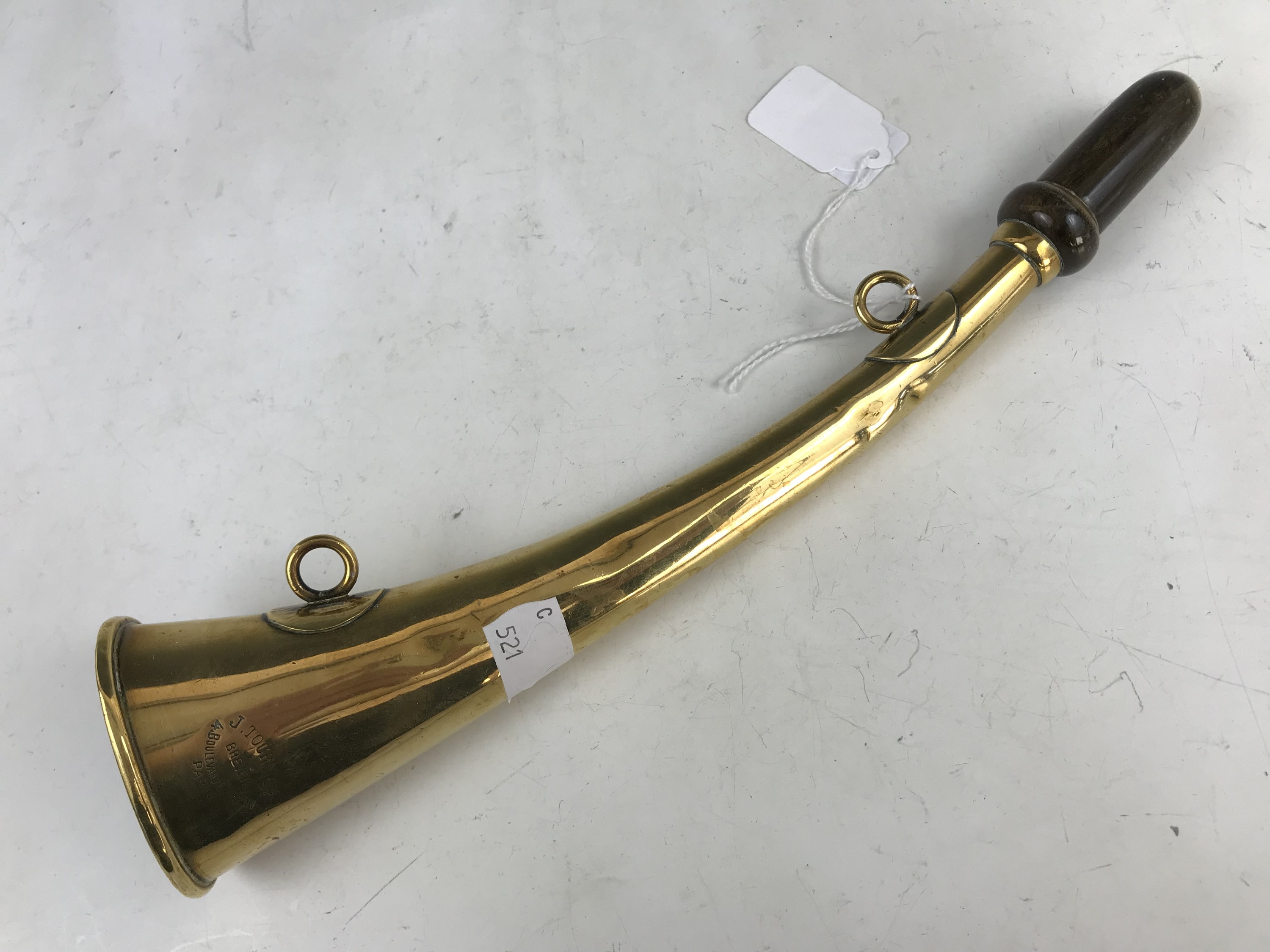 An antique brass horn retailed by J Tournier of Paris, 27 cm