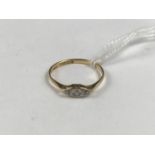 An Edwardian 18ct gold and diamond ring, having a shaped white-metal face set with three old-cut and