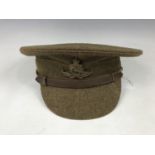 A British Army serge peaked cap, of other ranks' quality, bearing Royal Artillery cap badge,