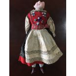A late 19th / early 20th Century porcelain doll wearing traditional Swiss costume, doll (a/f)