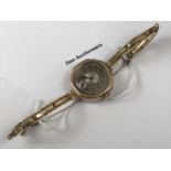A 1920s lady's 9ct gold cased wristlet watch, having a 15 jewel movement, a circular silvered face