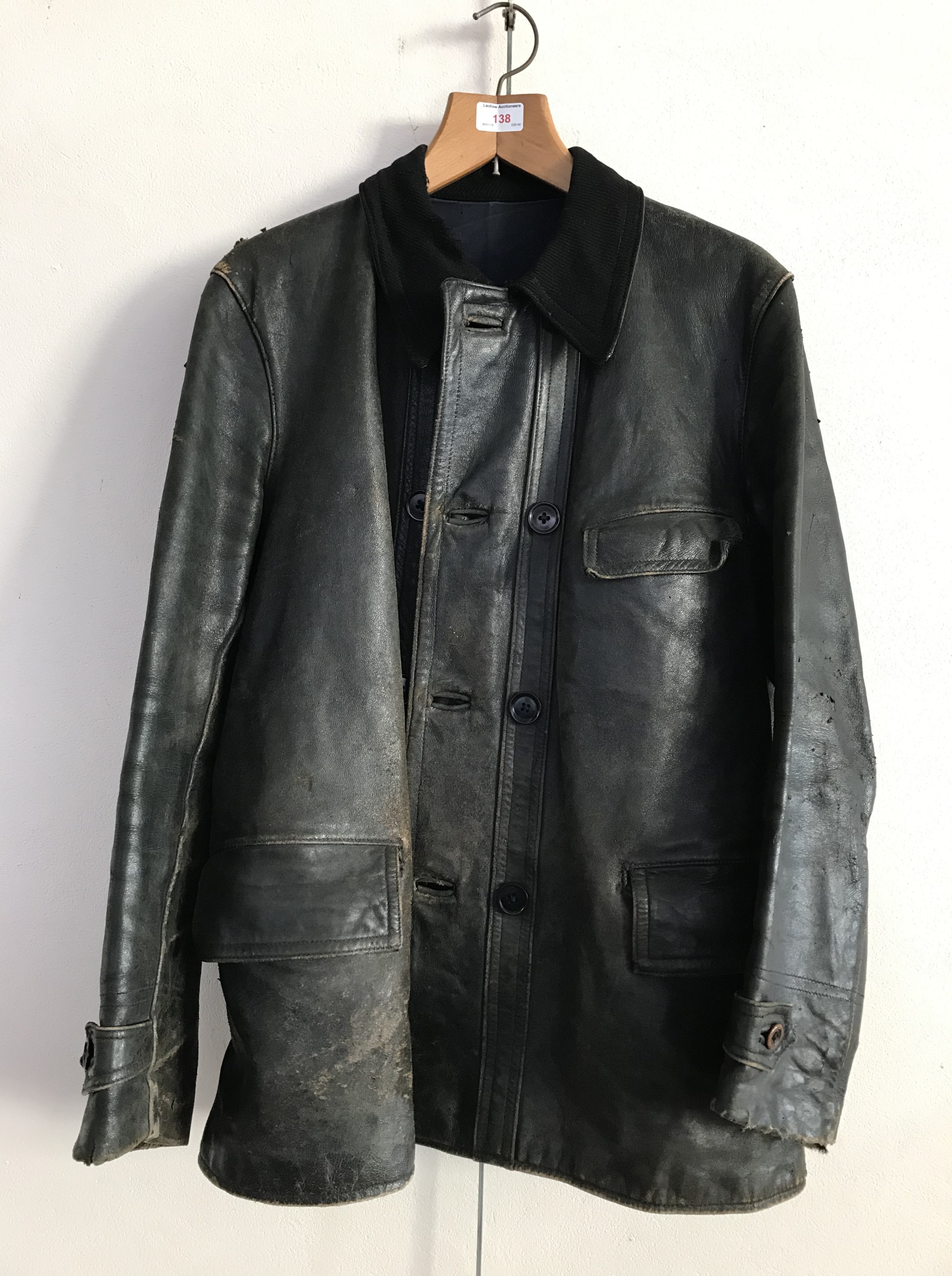 An inter-War black leather driving jacket bearing a machine-embroidered label which reads The