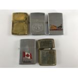 A brass Zippo lighter together with four others