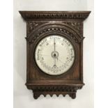 A late 19th / early 20th Century Maple & Co aneroid barometer in carved oak case, 43 cm, (glass