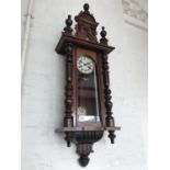 A 19th century Vienna wall clock, having a white enamelled dial, Gridiron pendulum and mahogany