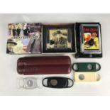A brown leather cigar case, together with Macanudo and other cigar cutters, and two boxed