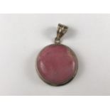 A contemporary pink mineral pendant cabochon pendant, the hardstone collet set in white metal,